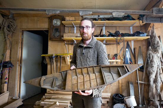 Rémy Colin perpetuates a local boatbuilding tradition in his workshop in Saint-Omer, France. In his hands, Rémy holds a small model of an escute, one of the types of vessels he builds (photo © Rudolf Abraham).